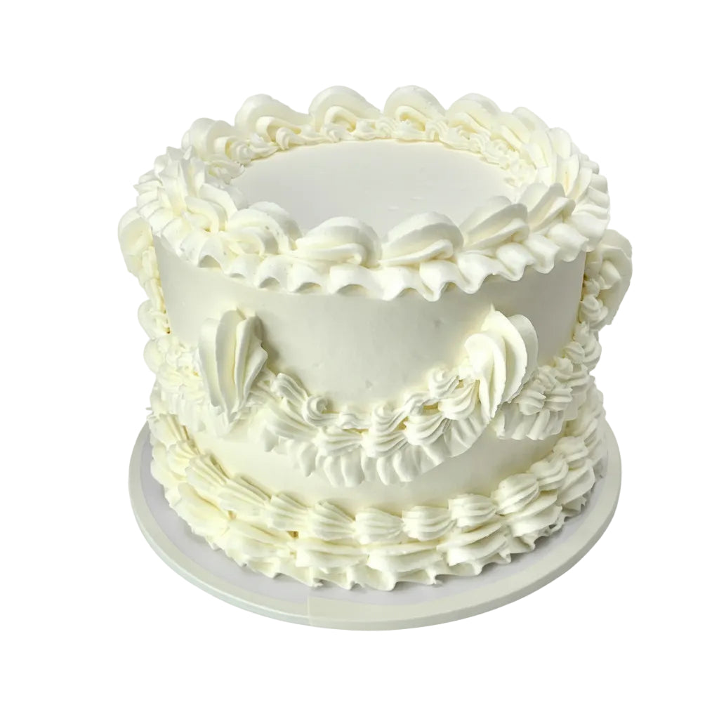 White frosted cake with decorative patterns on a white background