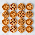 Assorted holiday tarts from The Makery Cake Co featuring spicy pumpkin tarts with pastry leaf decorations, cherry lattice tarts, and Dutch apple crumble tarts with golden streusel, perfect for Thanksgiving and Christmas celebrations in Centennial, Colorado.