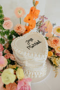 Heart shaped Just Married cake surrounded by flowers