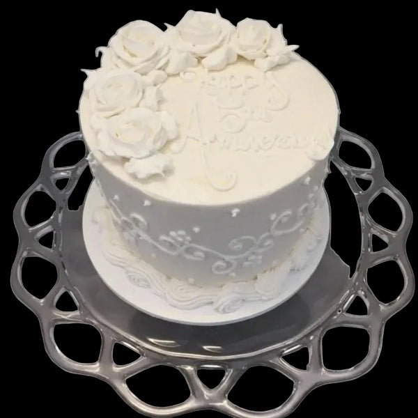 Anniversary Cake, An all white cake with buttercream roses on top and scrolls on the side