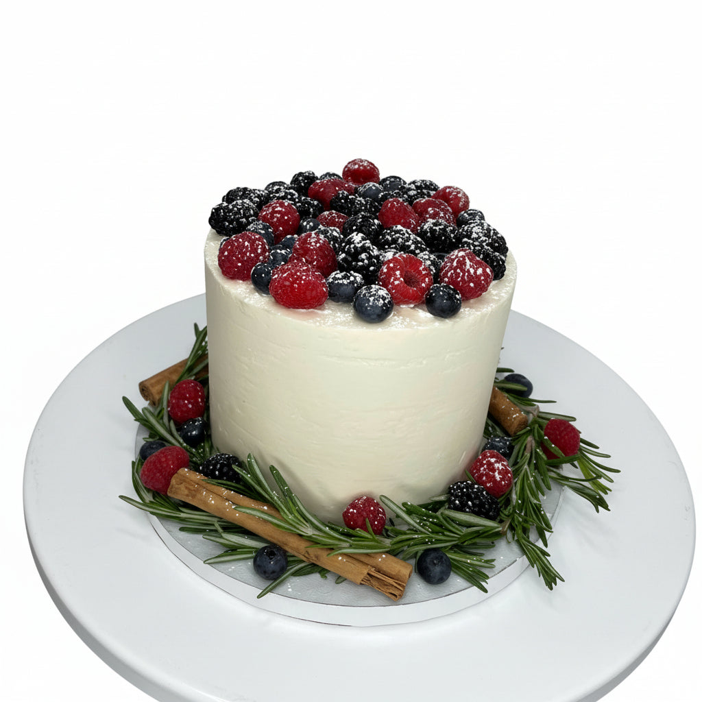 Holiday cake with berries, cinnamon sticks, and rosemary