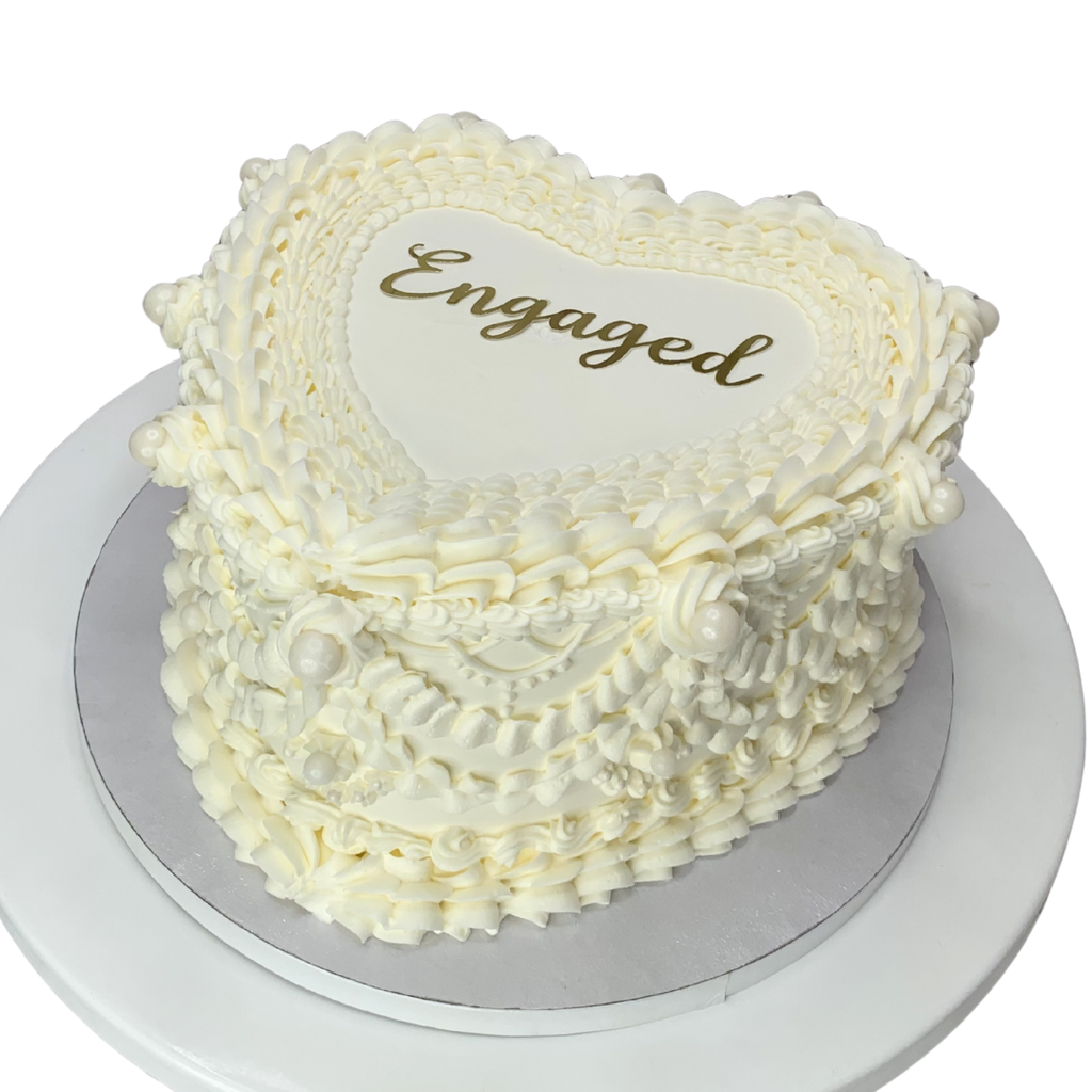 Heart shaped cake with vintage piping and and Engaged written on top