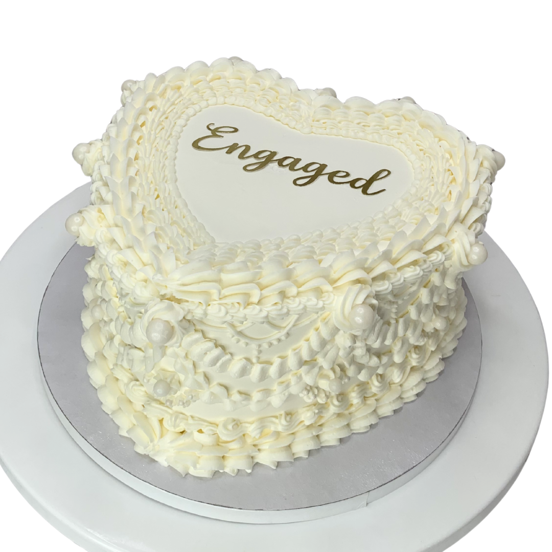 Heart shaped cake with vintage piping and and Engaged written on top