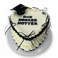 Heart-shaped cake with a graduation cap and 'ONE DEGREE HOTTER' text on a wooden surface.