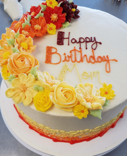 Moms Birthday Cake a color full cake with an ombre flower cascade on top