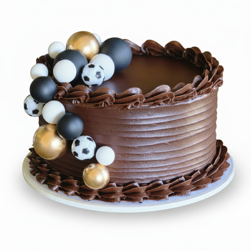 Chocolate cake with decorative sports ball toppers on a white background