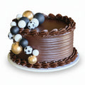 Chocolate cake with decorative sports ball toppers on a white background