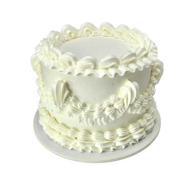 White frosted cake with decorative patterns on a white background