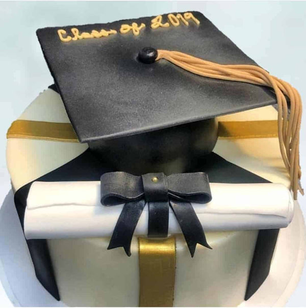Single Tiered cake with fondant stripes on the side and a graduation cap and graduation scroll on top
