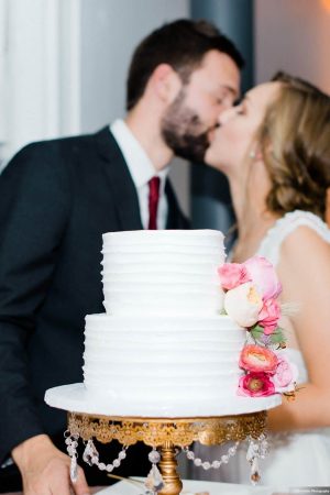 Couple kissing over wedding cake